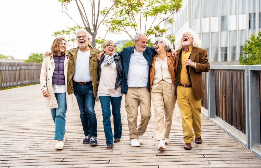 A group of happy seniors walking, smiling, and laughing together.